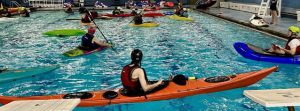 Julie at the pool with pack rafter, surf kayak...crazy.